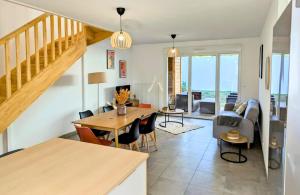 a dining room and living room with a table and chairs at Maison T4 jardin, garage, terrasse, bureau in Dax +28 photos