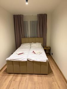 a bed in a bedroom with two slippers on it at Apartament Grodzka in Wałbrzych