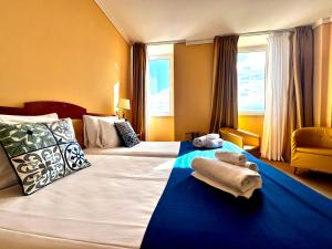 a hotel room with a large bed with towels on it at Greif Hotel Maria Theresia in Trieste