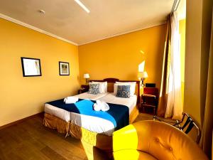 a hotel room with a bed and a chair at Greif Hotel Maria Theresia in Trieste