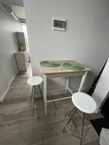 a small table and two stools in a room at 1 kambario apartamentai in Raseiniai