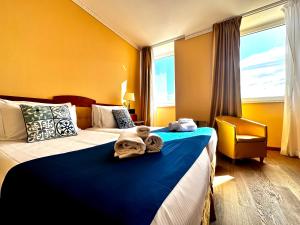 a hotel room with two beds with towels on them at Greif Hotel Maria Theresia in Trieste