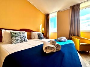 a hotel room with two beds with towels on them at Greif Hotel Maria Theresia in Trieste