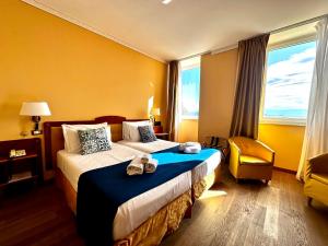 a hotel room with a bed and a chair at Greif Hotel Maria Theresia in Trieste