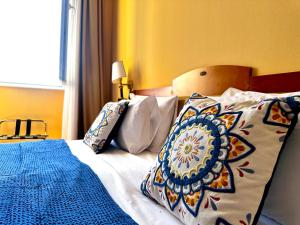 a bedroom with a bed with a blue blanket and pillows at Greif Hotel Maria Theresia in Trieste