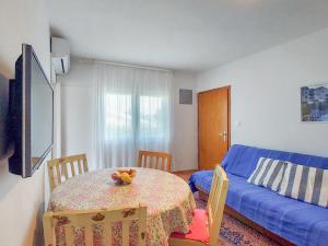 ニヴィーチェにあるApartment Martina by Interhomeのテーブルと青いソファのあるリビングルーム