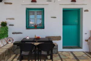 a patio with a table and a green door at Green Bay Studio 2 in Sifnos