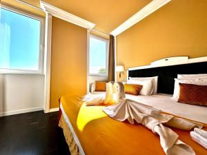 a bedroom with two beds and a large window at Greif Hotel Maria Theresia in Trieste