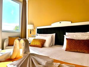 a bedroom with a large bed with a large headboard at Greif Hotel Maria Theresia in Trieste