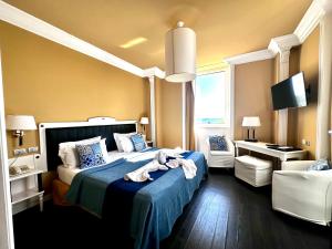 a bedroom with a bed with a blue comforter at Greif Hotel Maria Theresia in Trieste