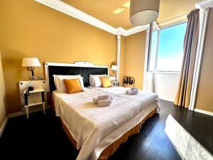 a bedroom with a large bed with yellow walls and a window at Greif Hotel Maria Theresia in Trieste