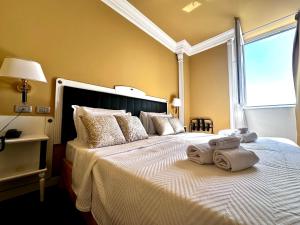 a bedroom with a large bed with towels on it at Greif Hotel Maria Theresia in Trieste