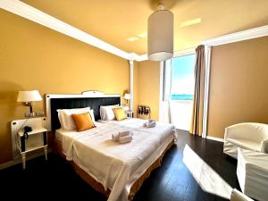 a bedroom with a large bed and a large window at Greif Hotel Maria Theresia in Trieste