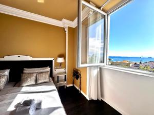 a bedroom with a bed and a large window at Greif Hotel Maria Theresia in Trieste