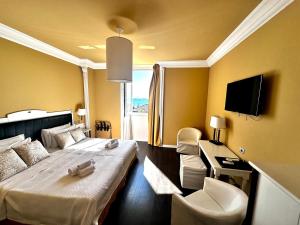 a hotel room with a bed and a tv at Greif Hotel Maria Theresia in Trieste