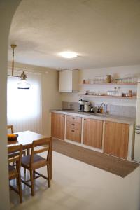 a kitchen with wooden cabinets and a table with chairs at Alba Terra Houses in Pamukkale
