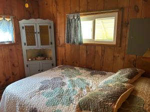 a bedroom with a bed and a window at Adirondack Waterfront Cabin Upper Hudson Tributary in Lake Luzerne