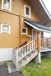 a wooden house with a staircase on the side of it at パウダー小屋 in Kutchan