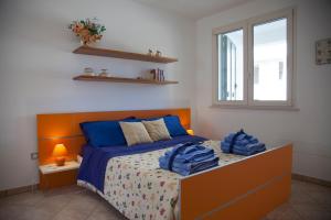 a bedroom with a bed with blue sheets and a window at Salento Mare Daniela in Leuca