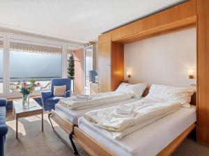 Un dormitorio con dos camas y una mesa y una silla. en Apartment Promenade - Utoring-34 by Interhome, en Arosa