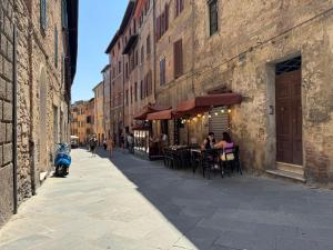 a street with people sitting at tables outside a building at Le terrazze di Camollia in Siena
