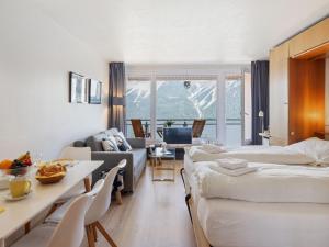 Una habitación de hotel con dos camas y una sala de estar. en Apartment Promenade - Utoring-60 by Interhome, en Arosa