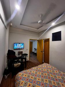 DargaiにあるStudio Apartment 5 mins away from beachのベッド、机、テレビのある寝室