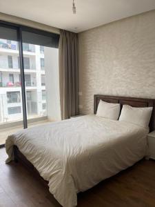 a bedroom with a large bed with a large window at Hajmbark in Agadir