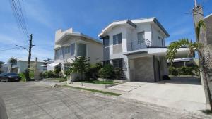 a white house with a car parked in front of it at 3-Bedroom House in NorthPoint in Talisay