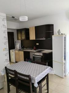 eine Küche mit einem Tisch und einem weißen Kühlschrank in der Unterkunft Apartament Morela in Sonnenstrand