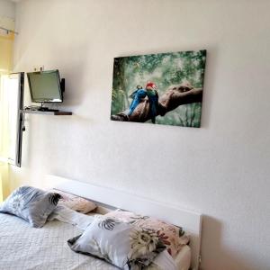 a bedroom with a picture of two parrots on the wall at Lovrić Studio mit Balkon in Jurandvor