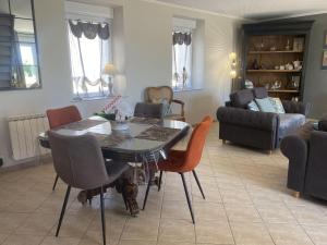ein Wohnzimmer mit einem Esstisch und Stühlen in der Unterkunft Holiday Home Cottage du Hamel es Clos by Interhome in Bretteville-sur-Ay