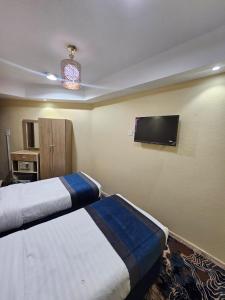 a hotel room with two beds and a flat screen tv at mina hotel in Riyadh