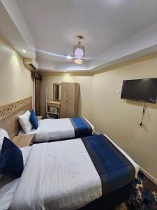 a hotel room with two beds and a flat screen tv at mina hotel in Riyadh