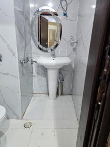 a white bathroom with a sink and a mirror at mina hotel in Riyadh