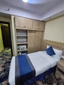 a bedroom with a large bed and wooden cabinets at mina hotel in Riyadh