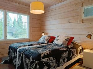 Un dormitorio con dos camas en una habitación con paredes de madera. en Kaarnikka, en Syöte