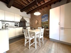 a kitchen with a white table and white chairs at Le terrazze di Camollia in Siena