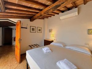 a bedroom with a white bed and a wooden ceiling at Le terrazze di Camollia in Siena
