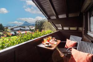 a balcony with a table and chairs and a view at Appartementhaus Ederegger in Ebbs +16 photos