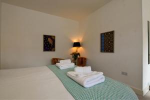 a bedroom with a bed with towels on it at The Dashwood Hotel by Aziz in Kirtlington