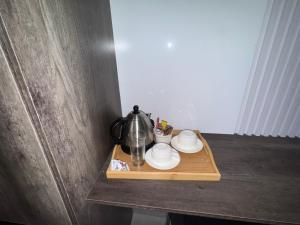 a tea pot and cups on a wooden tray at Mercy Accommodation Guest House in Jwaneng