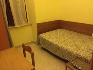 a small bedroom with a bed and a table at Hotel Euro in Genoa +10 photos