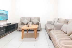 a living room with two couches and a coffee table at SPACIOUS 2BHK VACATION HOME IN DUBAI SHARJAH BORDER By MAUON COM in Sharjah