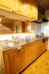 倶知安町にあるパウダー小屋のシンクと木製のキャビネットを備えたキッチン