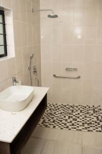 a bathroom with a sink and a shower at Mercy Accommodation Guest House in Jwaneng