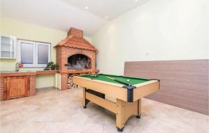 a pool table in a room with a brick oven at Beautiful Home In Jurdani With Wifi in Jurdani