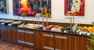 a buffet line with many different types of food at PLAZA Premium Berlin Kurfürstendamm in Berlin