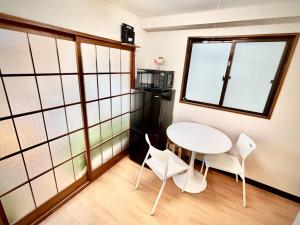 un tavolino e sedie in una stanza con finestre di 2F 3 minutes walk from Nishi-Oi Station, Shinagawa Ward, 4 stations available, surrounded by commercial streets, rich life, convenient transportation a Tokyo