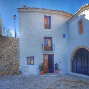 a white building with a door and a balcony at Cau de l'Art in Lucena del Cid